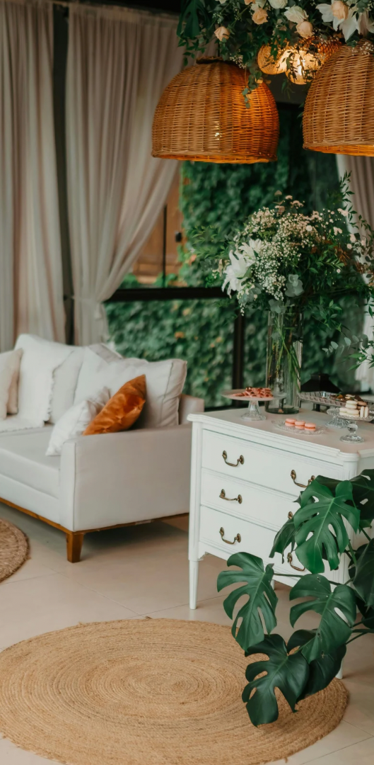 Helles Wohnzimmer mit beigem Sofa, Plants, Holztisch und runden Teppichen.