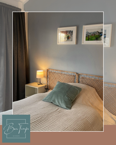 Gemütliches Schlafzimmer mit einem Bett, Nachttisch und einem Bild an der Wand.