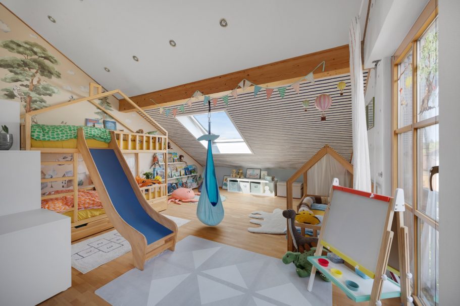 Bunte Spielzimmer mit Rutsche, Hängematte und kreativen Malutensilien.