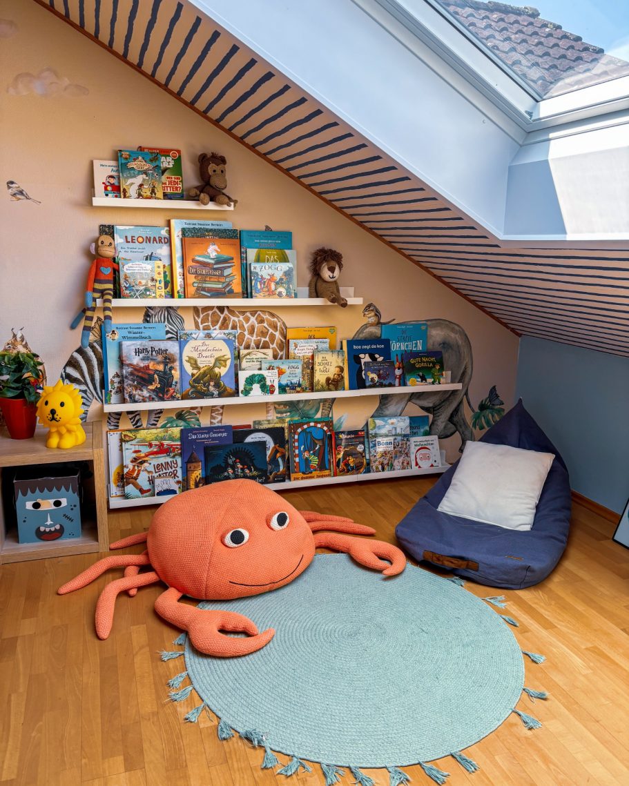 Gemütliches Kinderzimmer mit Bücherregal, einem Krabben-Kopfkissen und einem blauen Sitzsack.